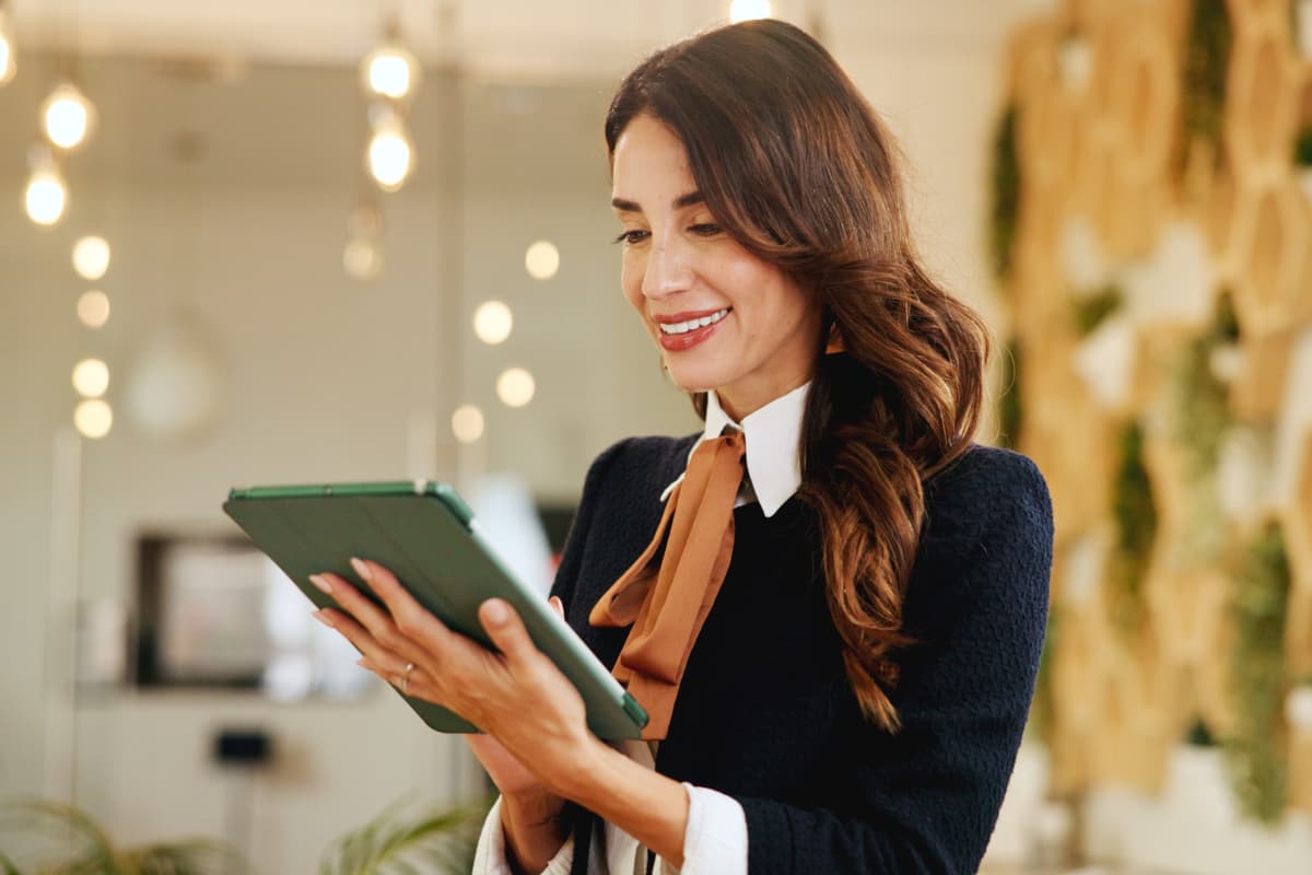 Responsable RH d’un hôtel utilisant une tablette pour gérer la paie de manière numérique.